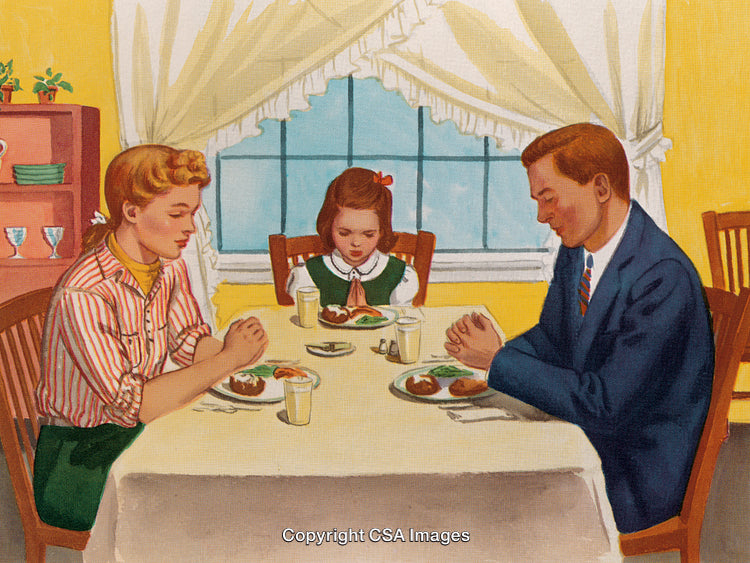 Family Praying Together Before a Meal at the Dinner Table