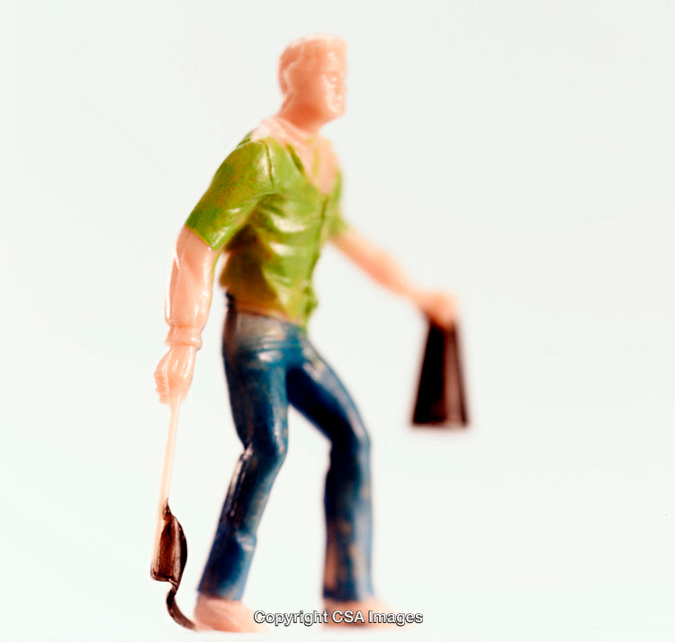 Plastic Toy Figure Holding Objects Against White Background