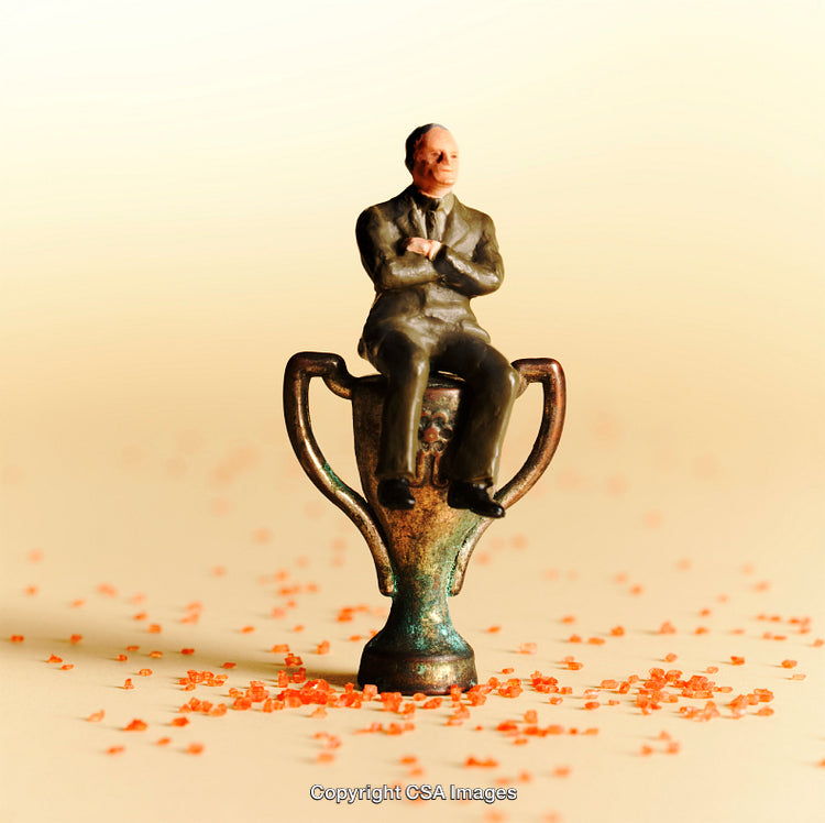 Miniature Man On Trophy Emphasizing Achievement And Success