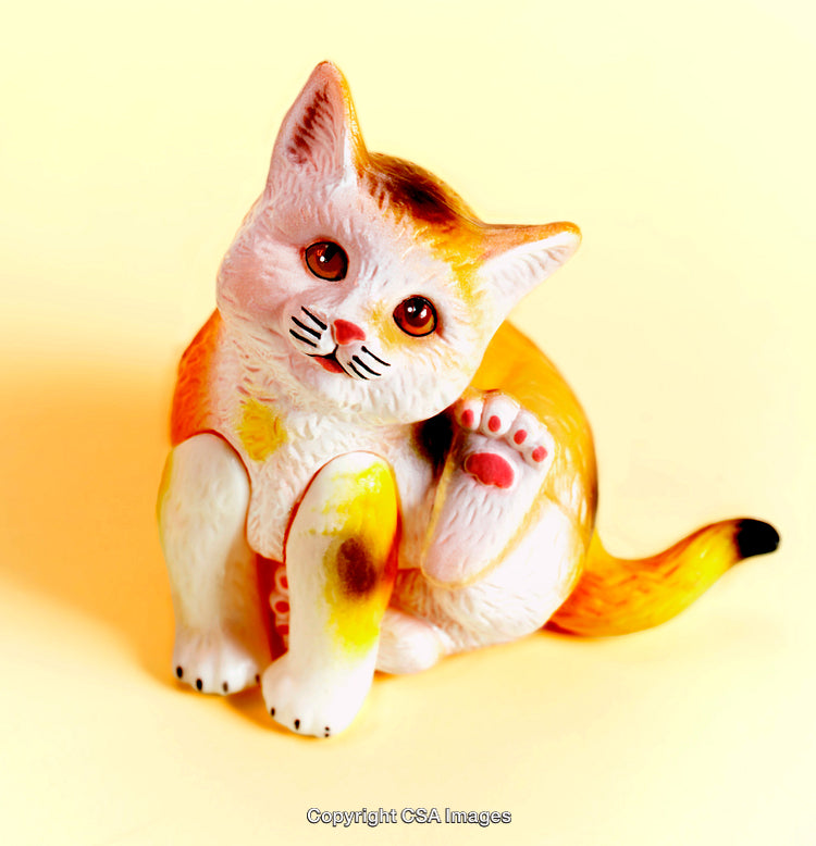 Adorable Plastic Cat Figurine With Bright Colors on Yellow Background