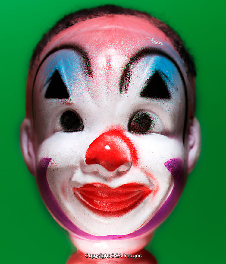 Close-Up of Playful Clown Toy Face on Vibrant Green Background