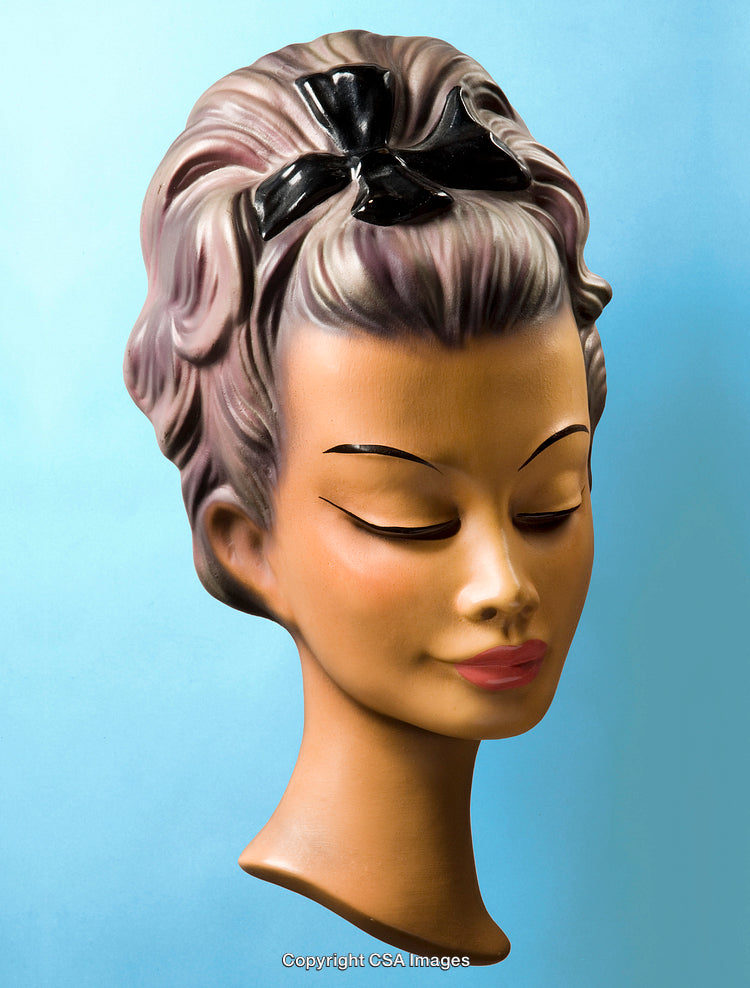 Close-Up of a Retro Inspired Female Mannequin Head on Blue Background