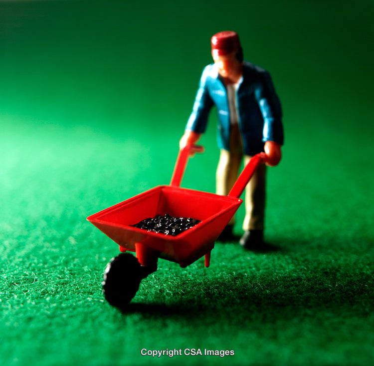 Miniature Figure Pushing Red Wheelbarrow on Green Surface