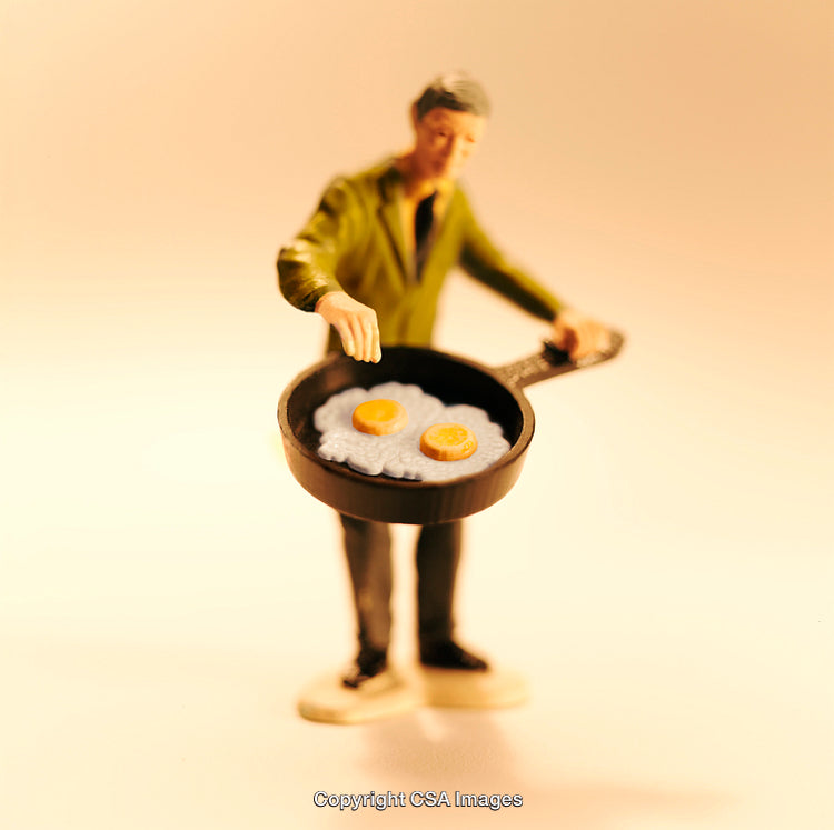 Miniature Figure Cooking Eggs in a Frypan with Artistic Lighting