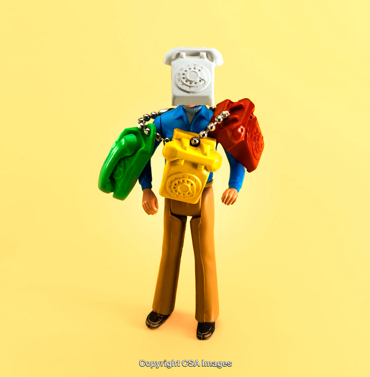 Creative Toy Arrangement with Colorful Telephones on a Yellow Background