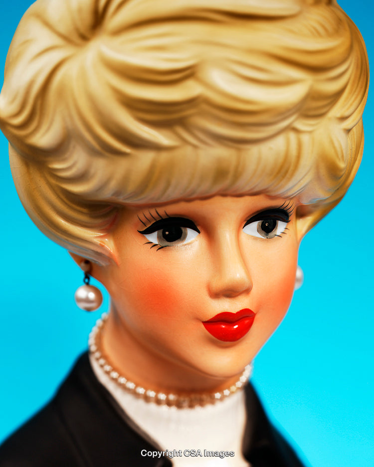 Close-Up of a Vintage Ceramic Lady Figurine on Blue Background
