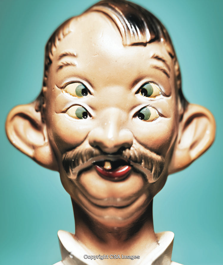 Close-Up of Unique Multi-Eyed Figurine Against Blue Background