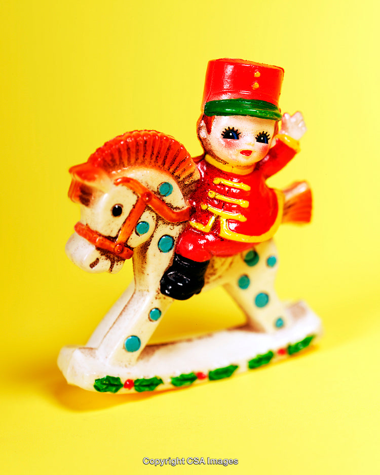 Vintage Toy Soldier Figurine on a Rocking Horse with Bright Yellow Background