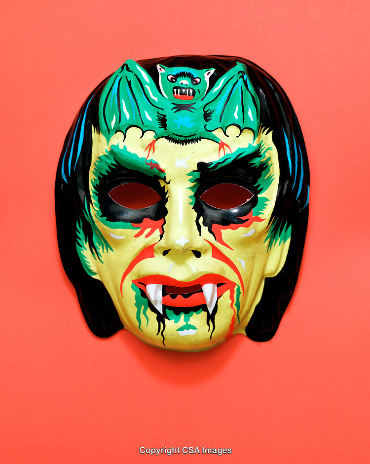 Colorful Vampire Mask with Bat Decoration Against Bright Red Background