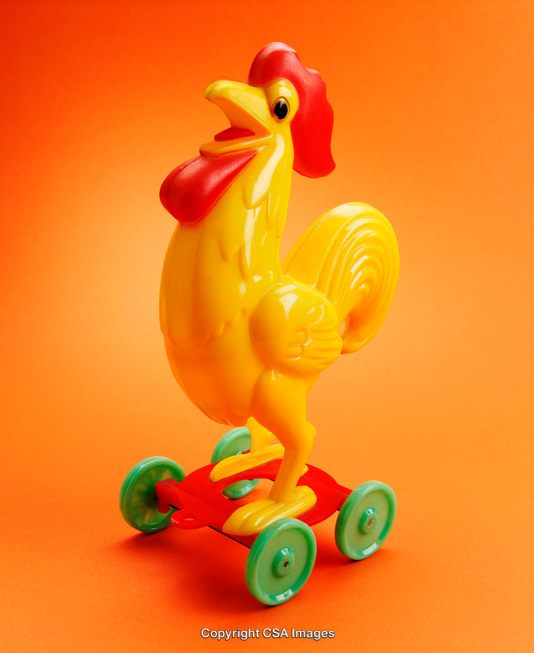 Bright Yellow Toy Rooster on Wheels With an Orange Background