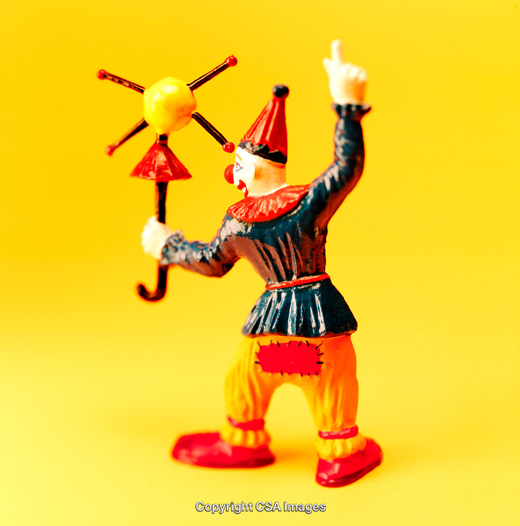 Colorful Clown Toy Figure Against a Vibrant Yellow Background