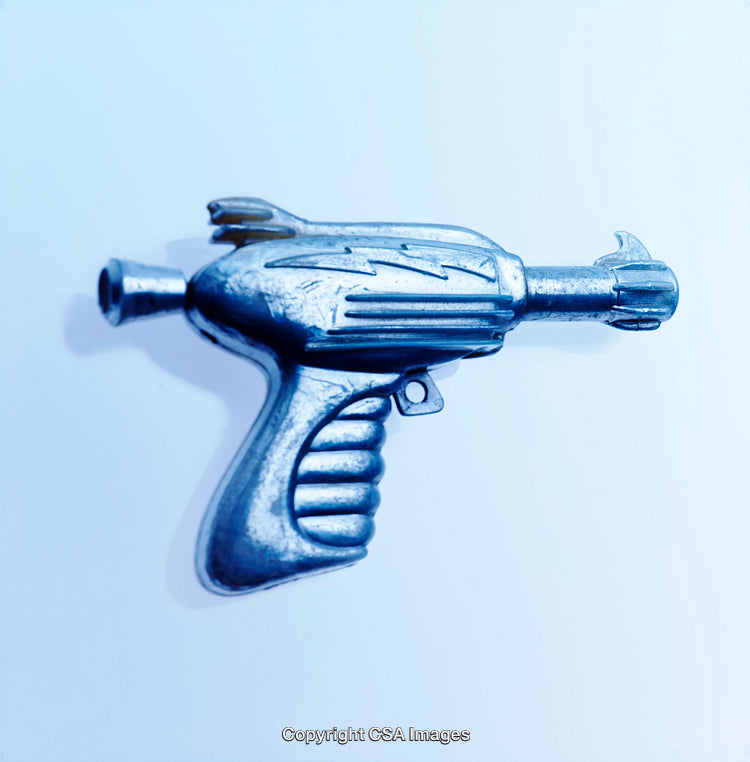 Retro Silver Ray Gun Toy on Blue Background Depicting Futuristic Themes