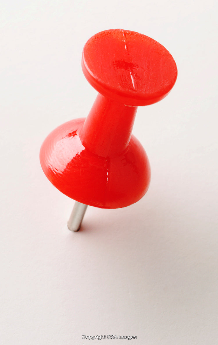 Close-Up of a Red Plastic Pushpin on a Light Background