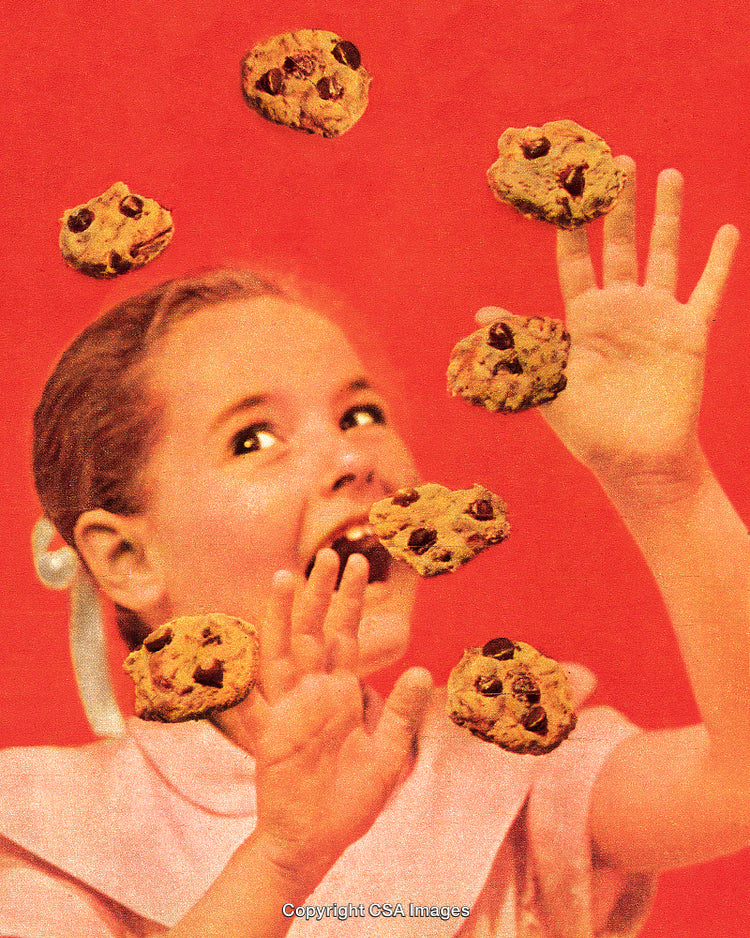 Excited Girl Reaching for Floating Chocolate Chip Cookies With Red Background