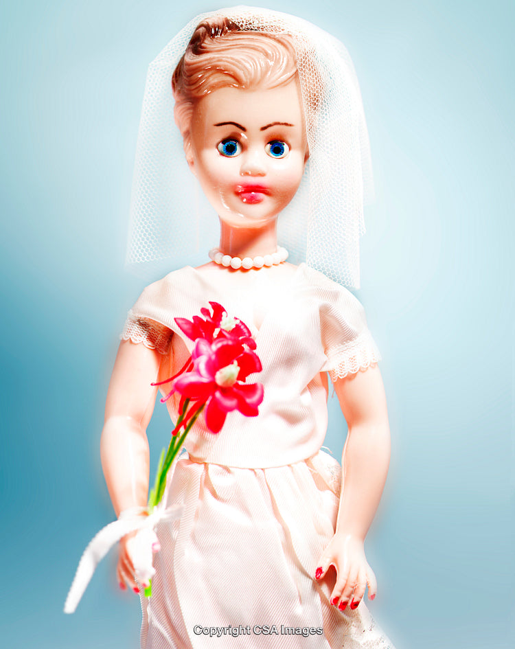 Plastic Bride Doll Holding Flowers Against Light Blue Background