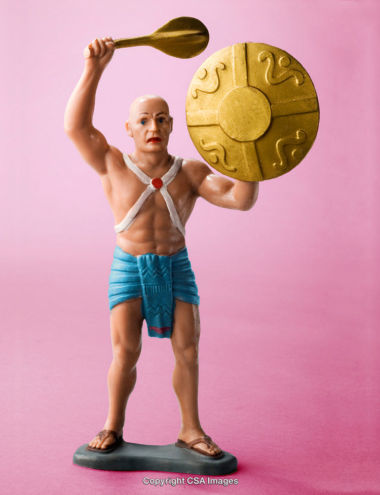 Plastic Figurine of a Warrior Holding a Shield and Weapon on Pink Background