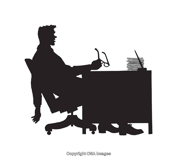 Silhouette of a Business Person Seated at Desk in Office Environment