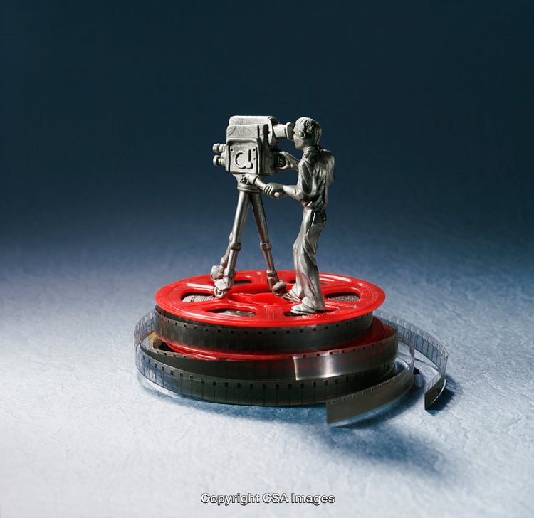 Figurine of a Cameraman with Film Reel on Artistic Background
