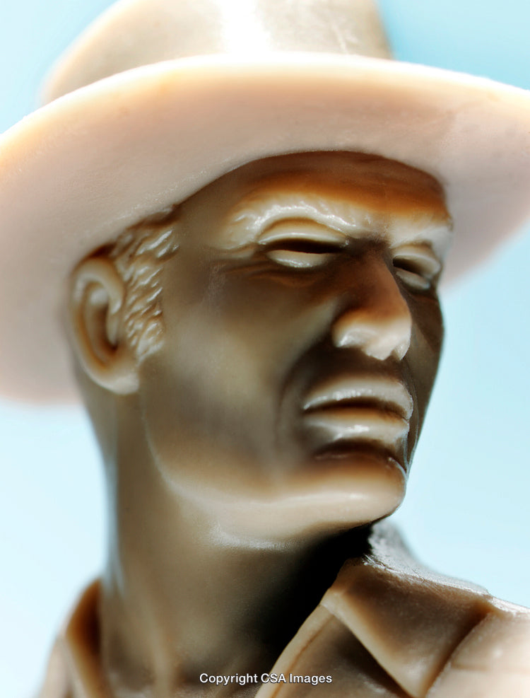 Close-Up of a Detailed Figurine With a Hat Against a Blue Background