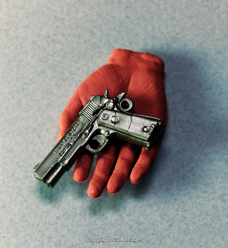 Red Gloved Hand Holding a Toy Firearm on Neutral Background