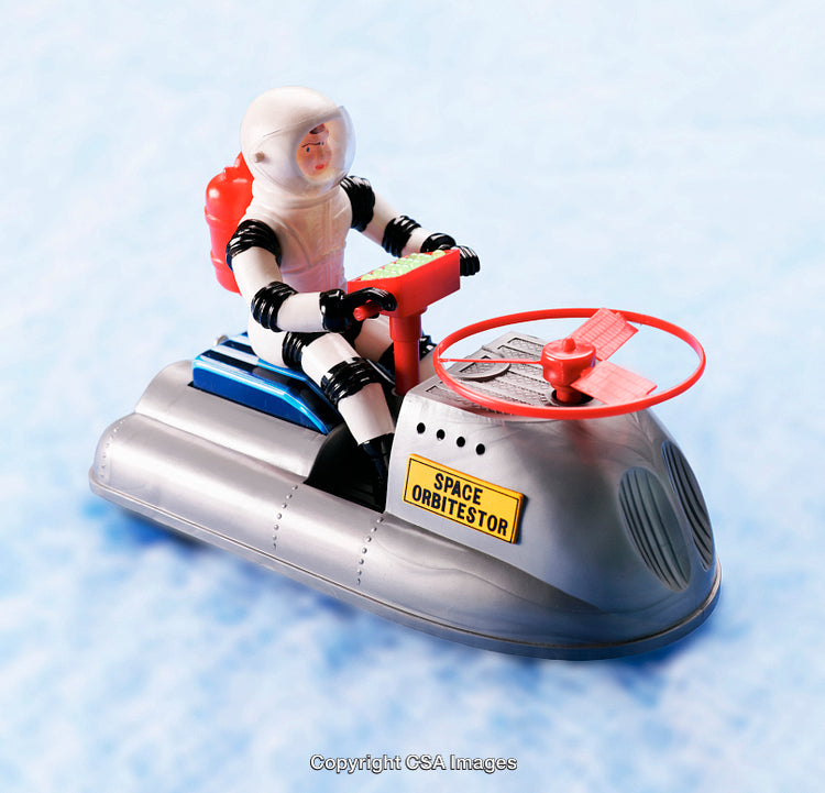 Vintage Plastic Space Toy on Hovercraft Against Blue Background