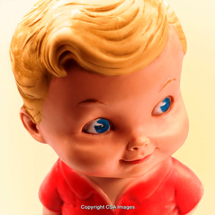 Close-Up of Vintage Blonde Plastic Toy with Blue Eyes in Red Outfit