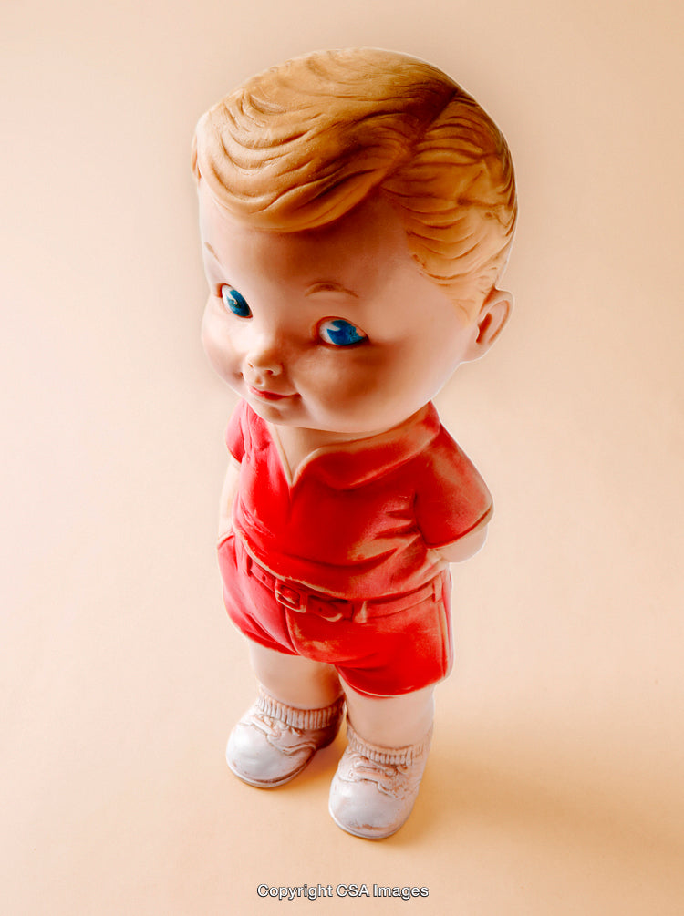 Vintage Plastic Toy Figurine of a Boy in Red Outfit on Neutral Background