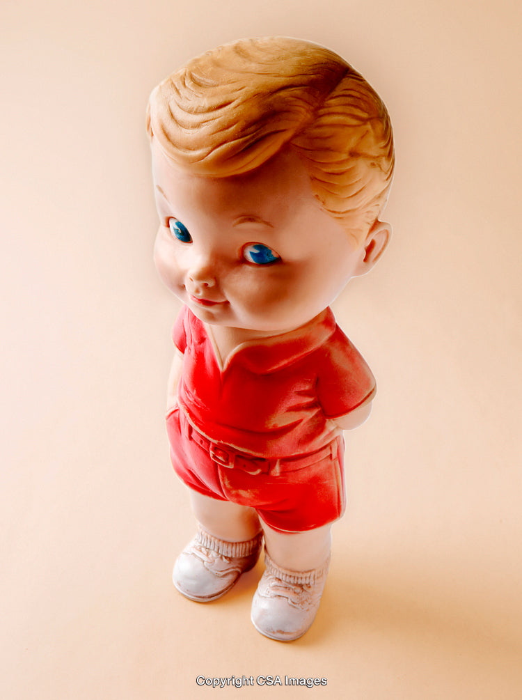 Vintage Plastic Toy Figurine of a Boy in Red Outfit on Neutral Background