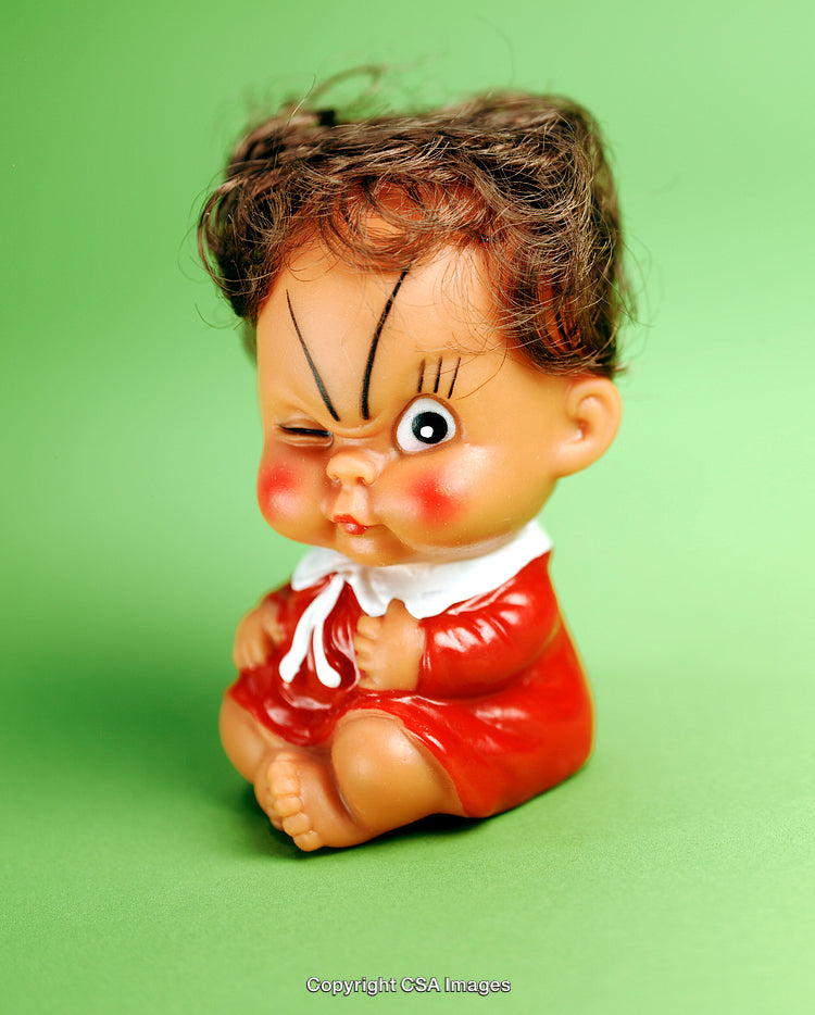 Cute Plastic Doll with Winking Expression on Green Background