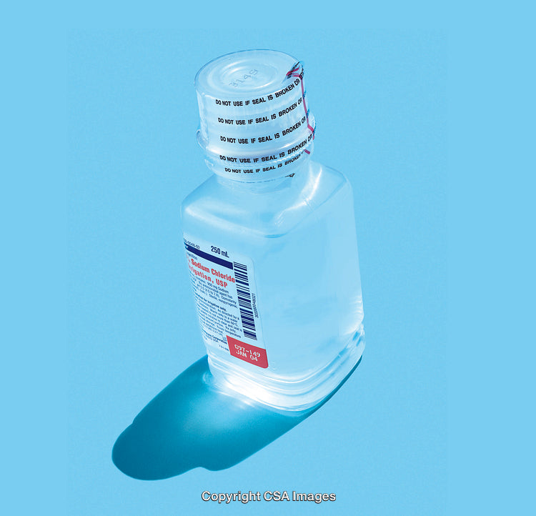 Bottle of Sodium Chloride Solution Against Blue Background