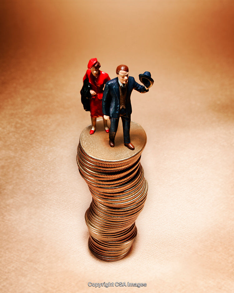 Miniature Business Figures Standing on a Stack of Coins Highlighting Wealth