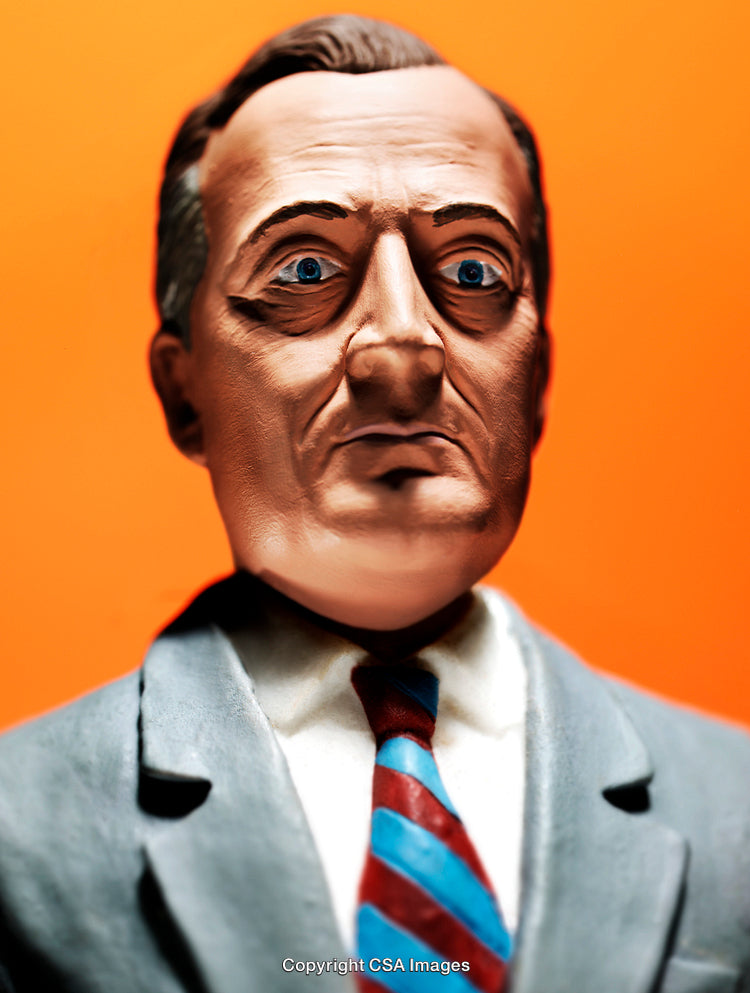 Close-Up of a Figurine in a Suit Against Vibrant Orange Background