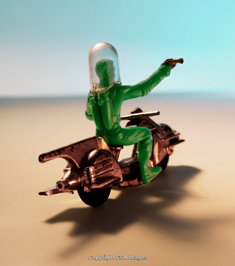 Green Plastic Figure Riding Futuristic Bike in a Minimal Setting