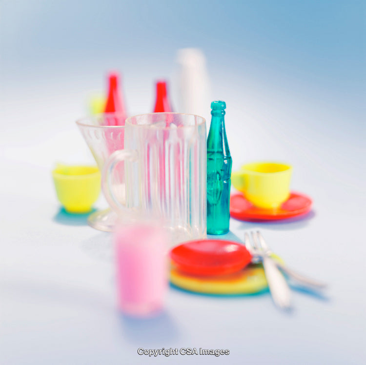 Colorful Toy Tea Set and Plastic Bottles on Blue Background