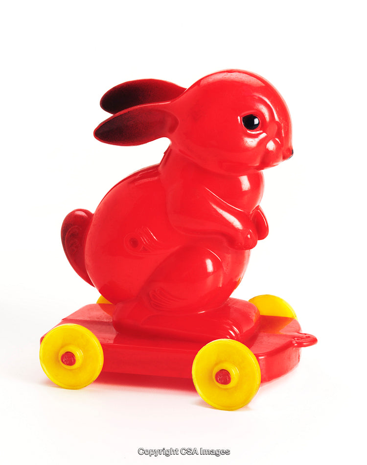 Red Plastic Bunny Toy on Yellow Wheels Isolated on White