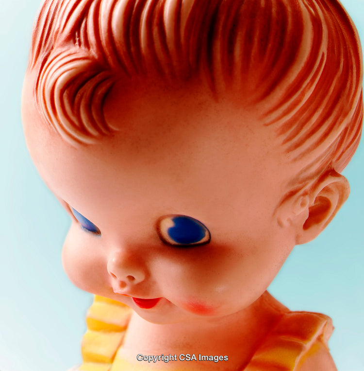 Close-Up View of a Vintage Doll with Blue Eyes on Soft Background