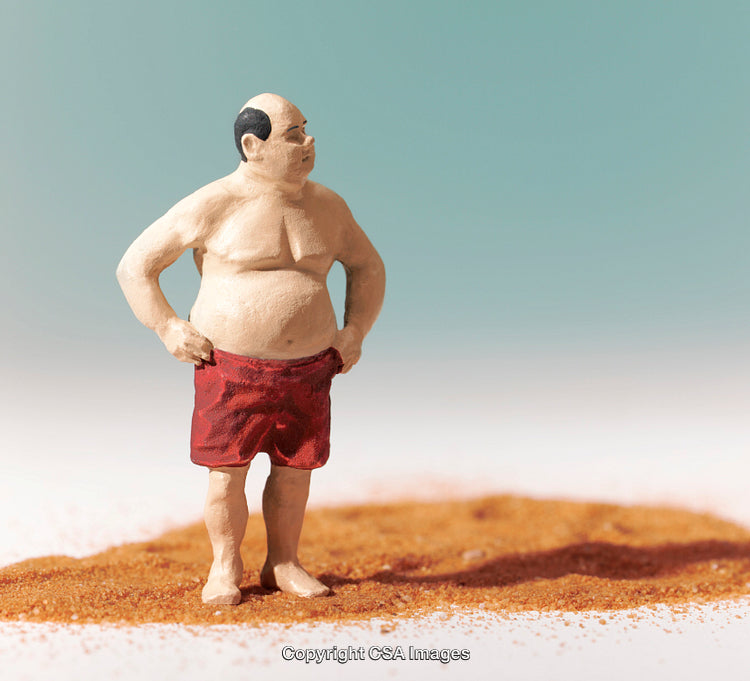 Small Figure of a Man Standing In Isolation on Sandy Surface