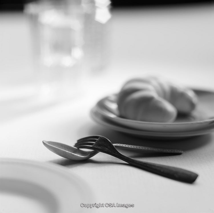 Monochrome Breakfast Scene with Cutlery and Croissant on Table