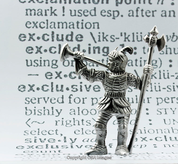 Metallic Knight Figurine Against Dictionary Page Background