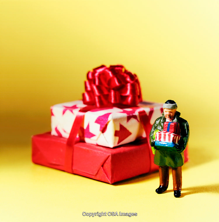 Whimsical Figurine Holding Gifts Beside Decorated Presents on Yellow Background