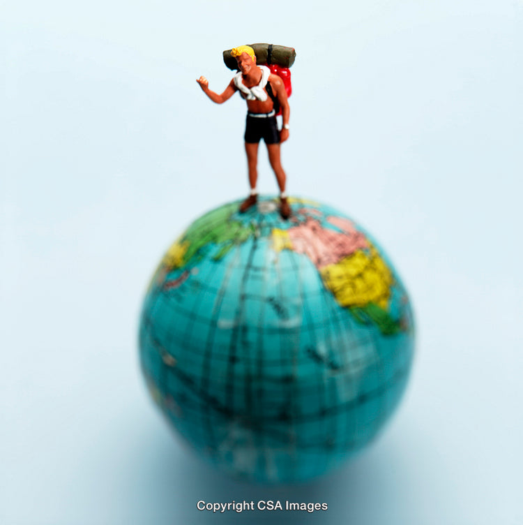 Miniature Backpacker Figure on a Globe Symbolizing Global Travel Adventure