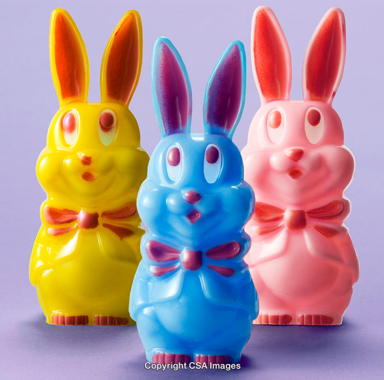 Colorful Plastic Rabbit Figurines in Yellow, Blue, and Pink on Purple Background