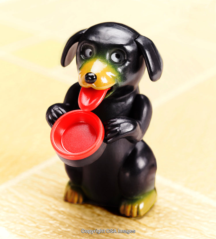 Colorful Plastic Dog Figurine Holding a Red Bowl on a Textured Surface