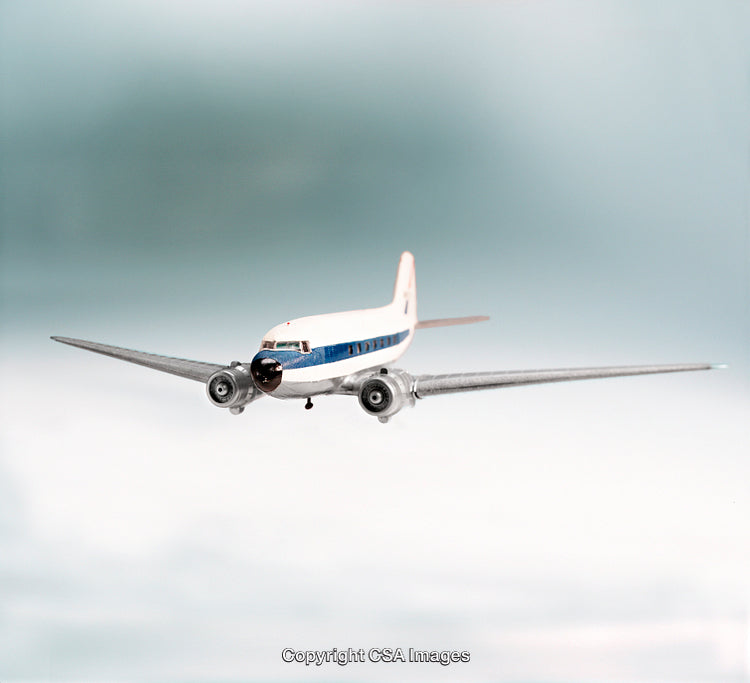 Vintage Airplane Model in Flight Against a Soft Gradient Background