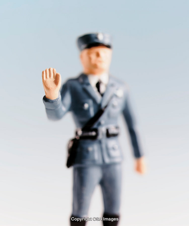 Miniature Police Figure Gesturing in Uniform Staged on Gradient Background
