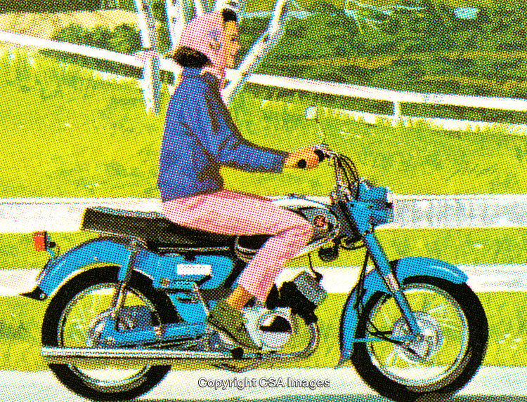 Woman Rides Blue Motorcycle Through Scenic Green Countryside Road