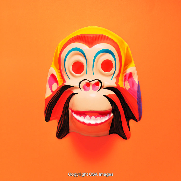 Colorful Monkey Mask Against Bright Orange Background
