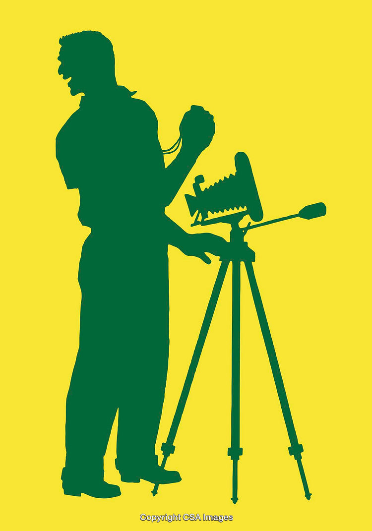 Silhouette of a Photographer Operating a Classic Camera on Tripod Stand
