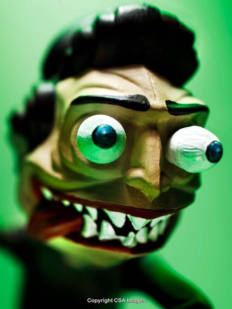 Close-Up of a Cartoonish Toy Figure with Exaggerated Features on Green Background