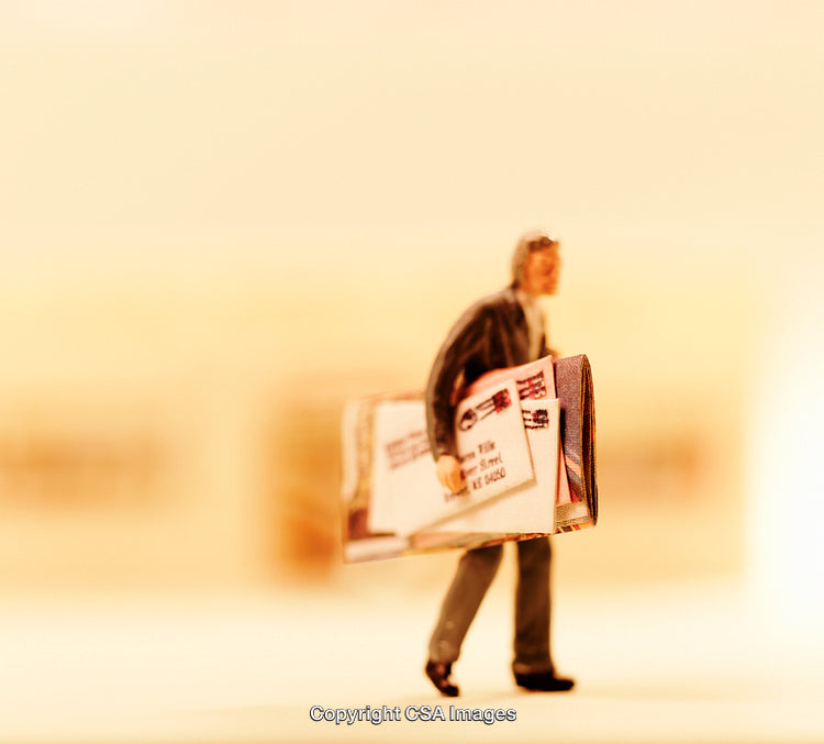 Miniature Figurine Carrying Mail in Warm Lighting Focused on Details